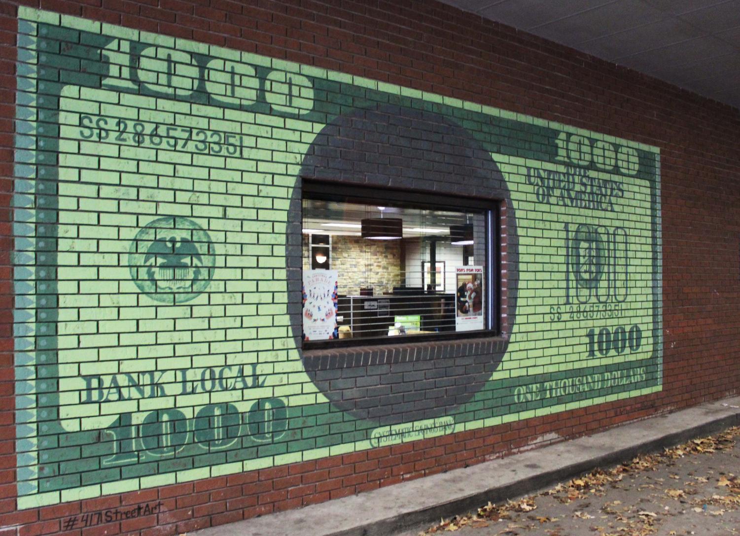 A bank vault with money hidden inside plastered on a brick wall in an alley.