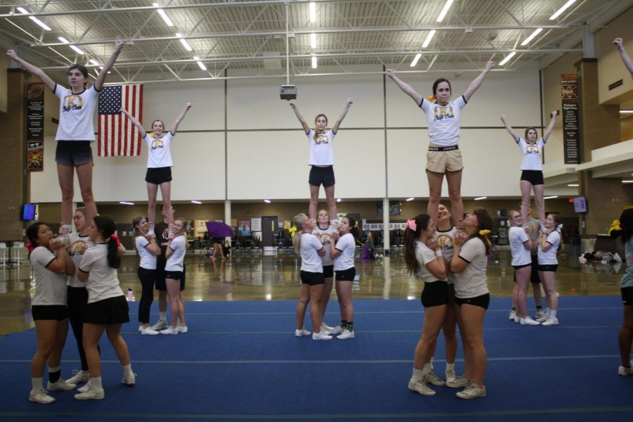 The cheer team practices a stunt commonly done at tryouts. 