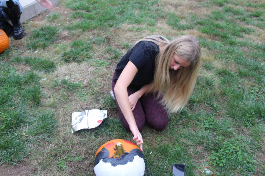 Maggie Miller (12) paints pumpkin.
