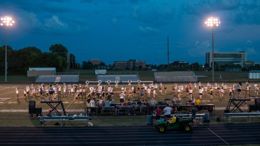 The Kickapoo Golden Arrow Band prepares for an upcoming competition on the football field.