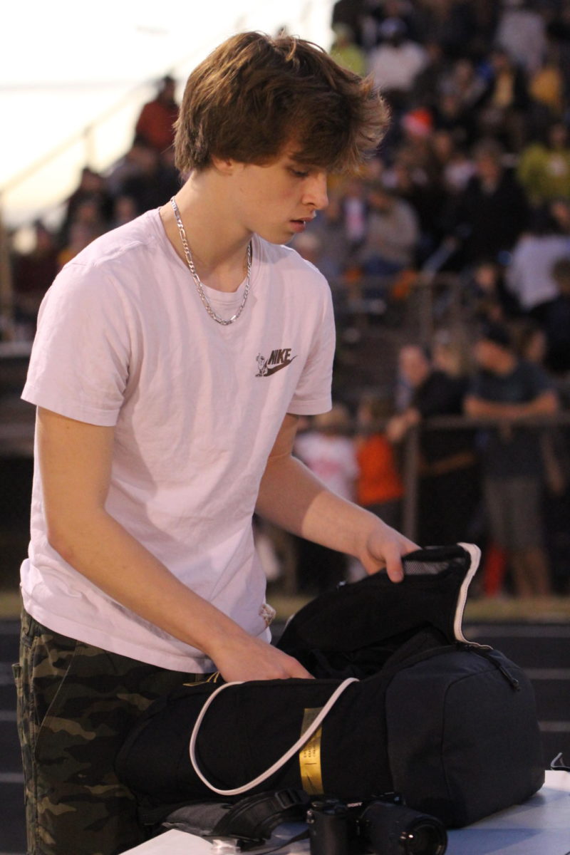 Sophomore Vincent Mhire takes inventory of his equipment during a game break.