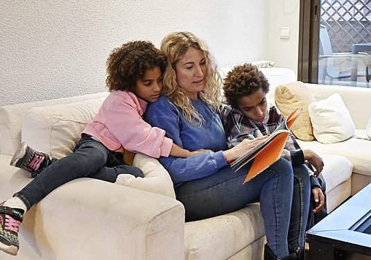 By taking the time to read with them, parents can play a role in building their childs literacy skills. Photo courtesy of Wikimedia Commons. 