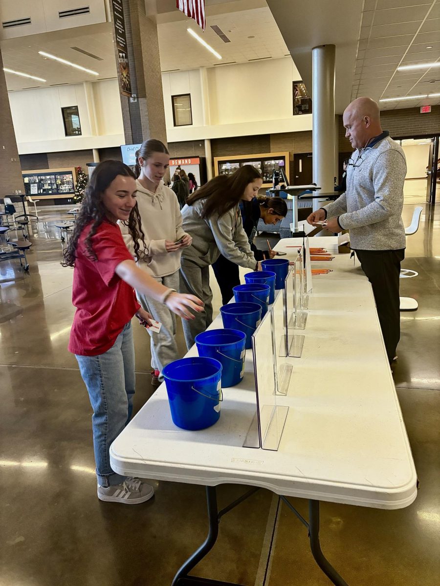 Assistant principal, Scot Phillips, helping students enter their Chief Bucks into the raffles. 