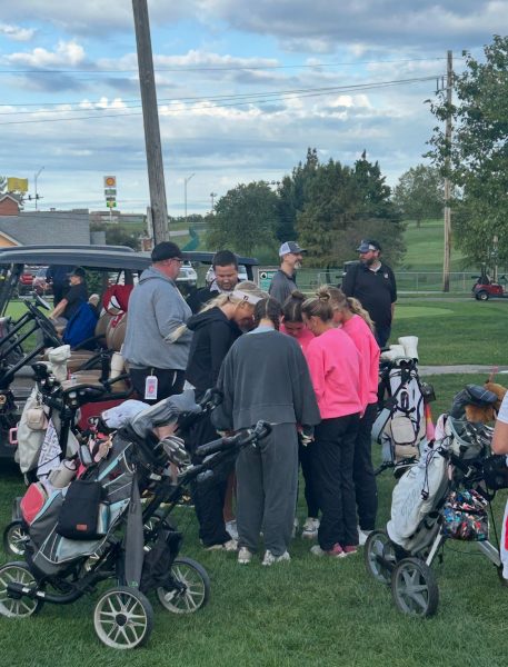 The golf team shows how close they are by praying together before a match.